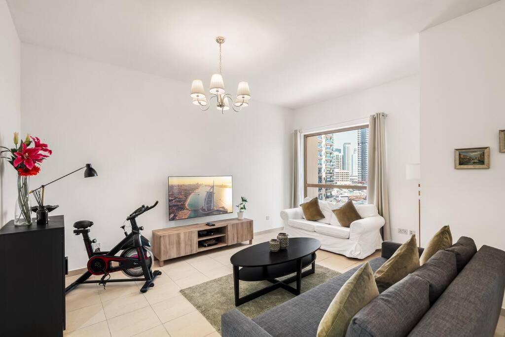a living room with a couch and a bike in it at Sunkissed holiday homes 2-3BR Apartments on JBR beach near mall & metro & bluewaters Island in Dubai