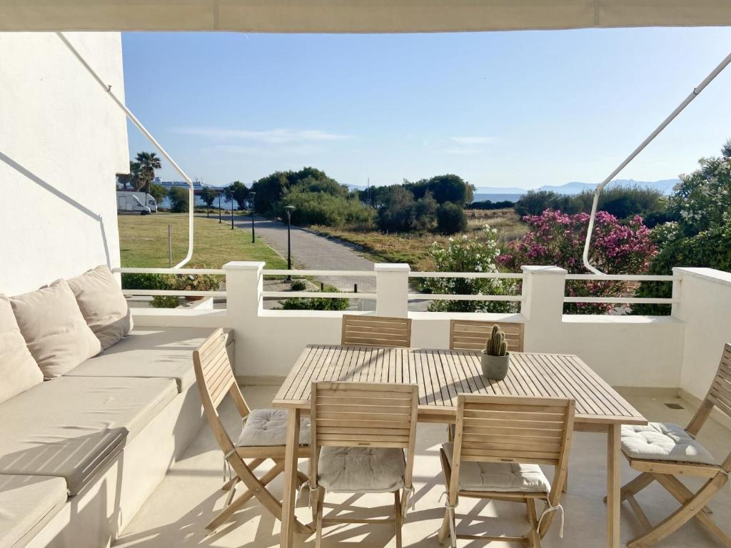 a patio with a table and chairs on a balcony at Maia beach house in Rafina