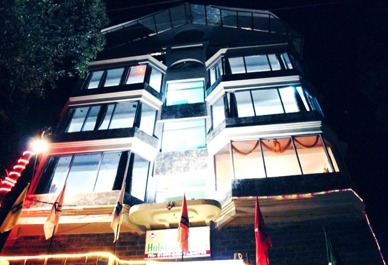 um edifício alto com bandeiras à frente em Hotel Plaza Dalhousie - Near Ghandhi Chowk Mall Road em Dalhousie