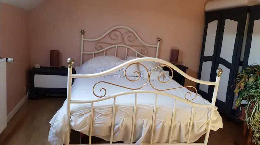 a white bed in a room with a plant at Chambre agréable à proximité de Disneyland Paris JO in Nanteuil-lès-Meaux