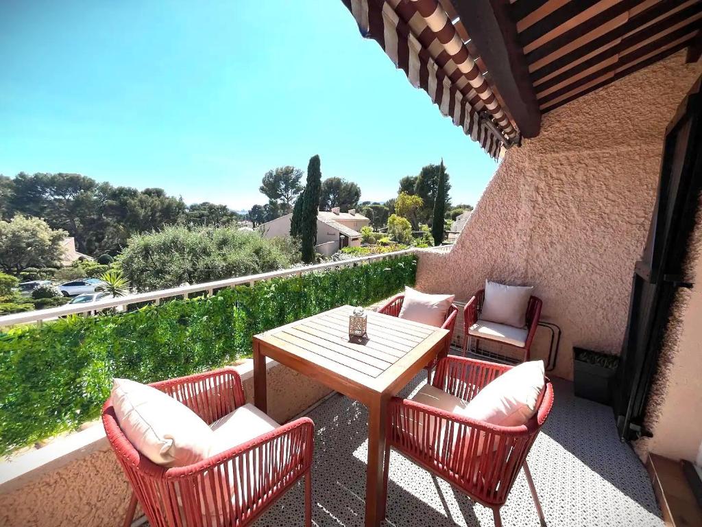 a patio with a table and chairs on a balcony at CICADA - Wifi, Clim, Vue Mer, Parking Gratuit in La Ciotat