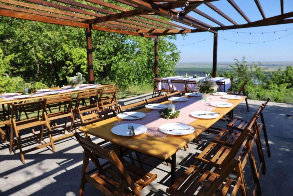 a long wooden table and chairs on a patio at Casa Horizont in Slankamenački Vinogradi