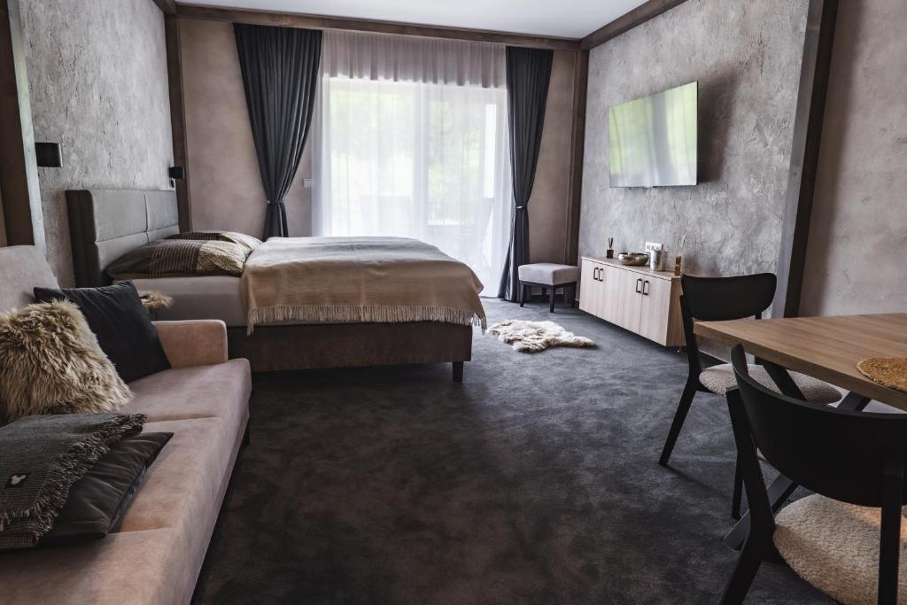 um quarto de hotel com uma cama e um sofá em Luxusní apartmán Domovjanka - MEDVĚDÍN em Bílá