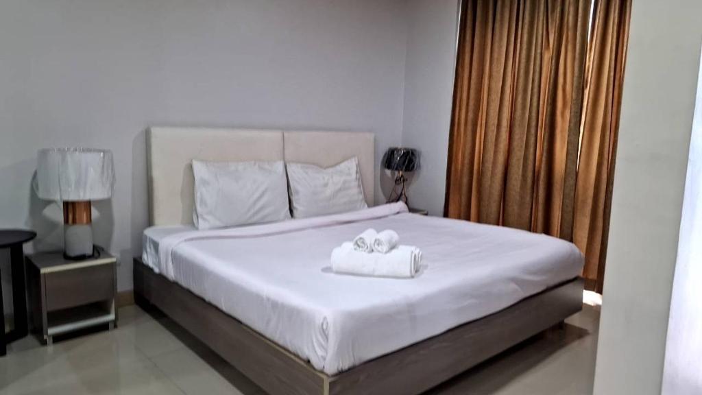 a bedroom with a bed with two towels on it at LIV@5 Condominium in Makkasan