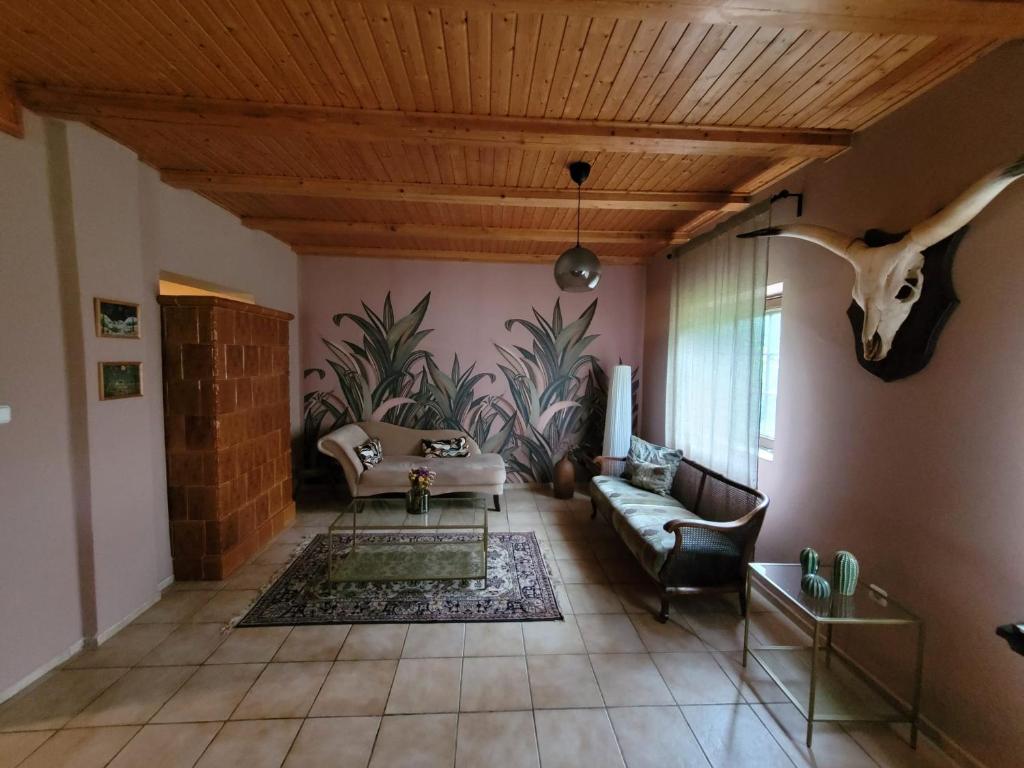 una sala de estar con una cabeza de dinosaurio en la pared en Ferienhaus am Theiß-See Bella en Tiszaderzs