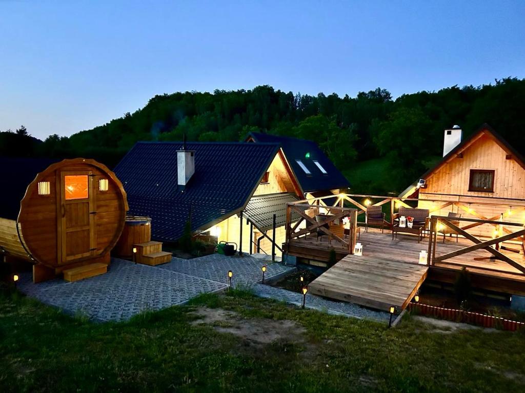 un groupe de bâtiments en bois avec une terrasse en bois dans l'établissement Siedlisko Złota Góra domki całoroczne na Kaszubach, à Brodnica