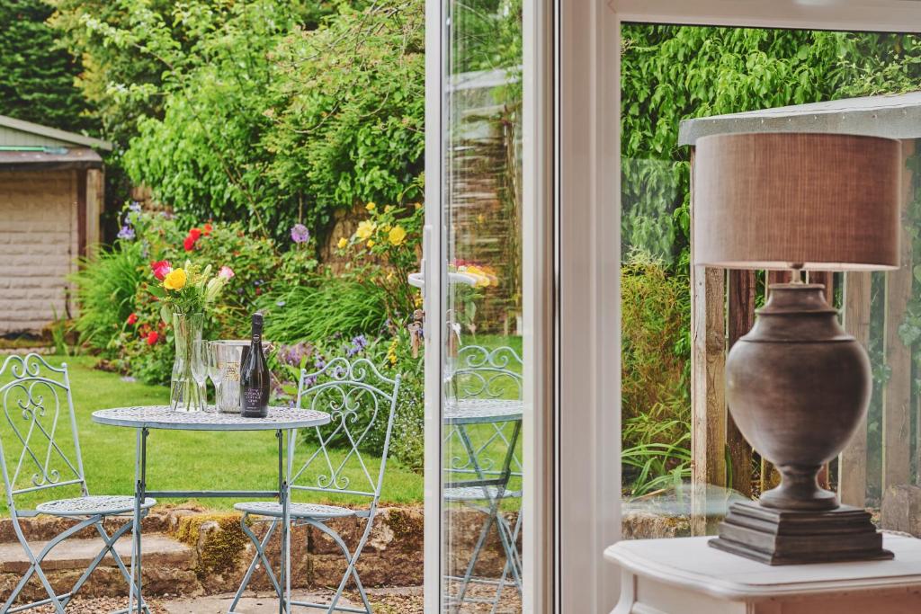 una lámpara sentada en una mesa junto a una ventana en The Lansdowne Guest House en Bourton on the Water