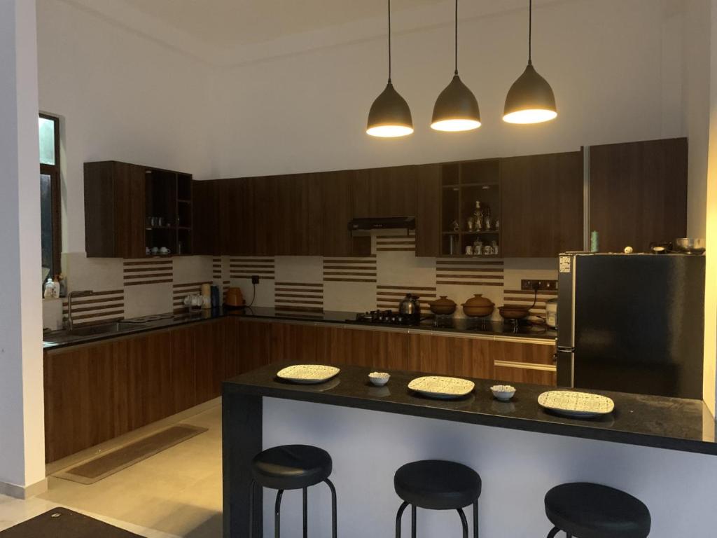 a kitchen with a counter with stools and a refrigerator at 3 BHK furnished house-apartment in central colombo in Colombo