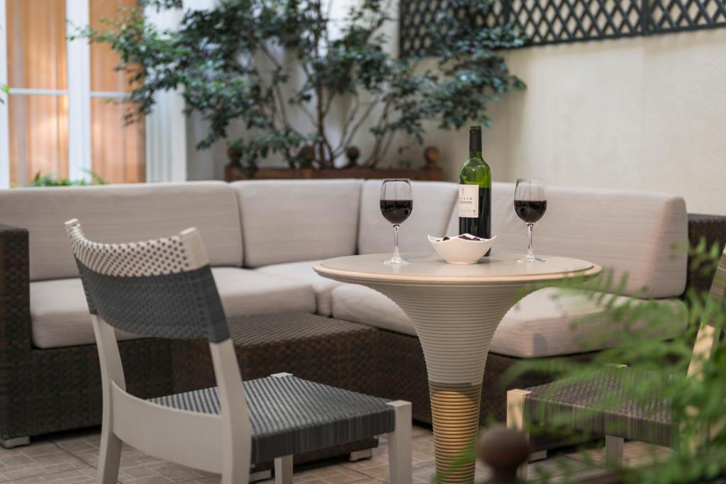 a table with two glasses of wine and a couch at Magda Champs Elysées in Paris