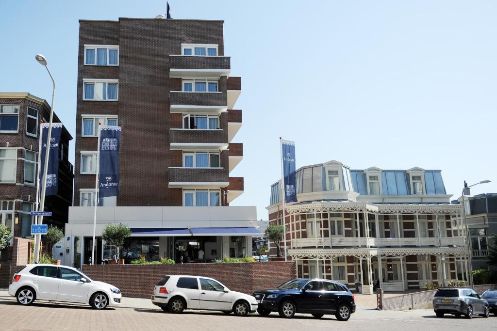 een groep auto's geparkeerd voor een gebouw bij Hotel Andante aan Zee in Scheveningen