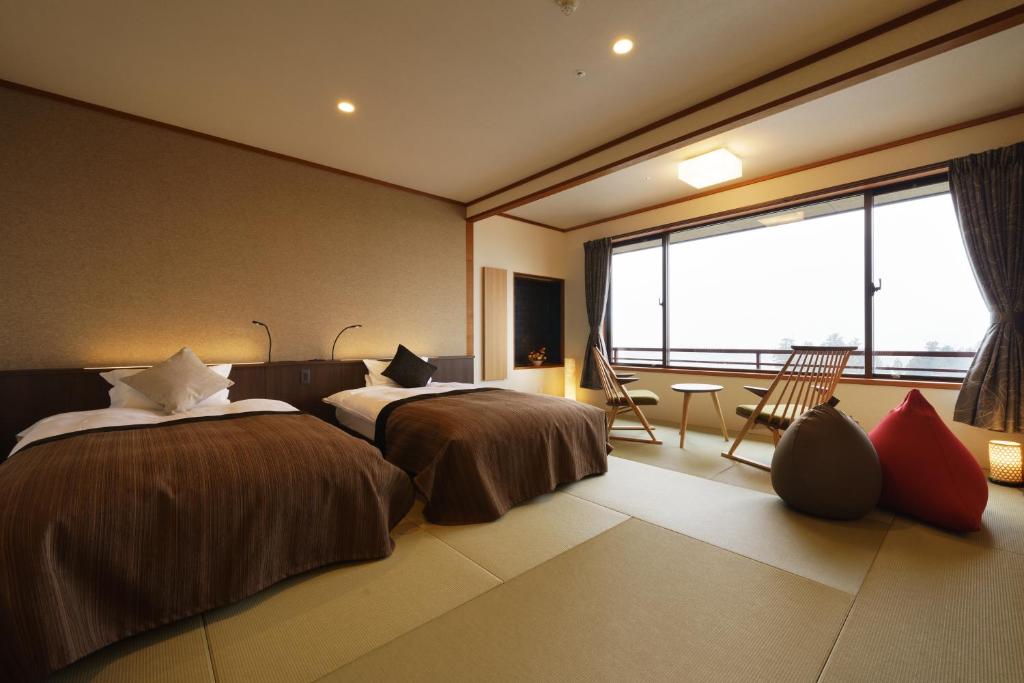 Postel nebo postele na pokoji v ubytování Kintarou Onsen Hotel