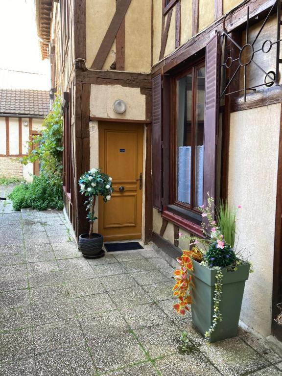 une porte d'un bâtiment avec des plantes devant lui dans l'établissement Cocon Bleu, à Troyes