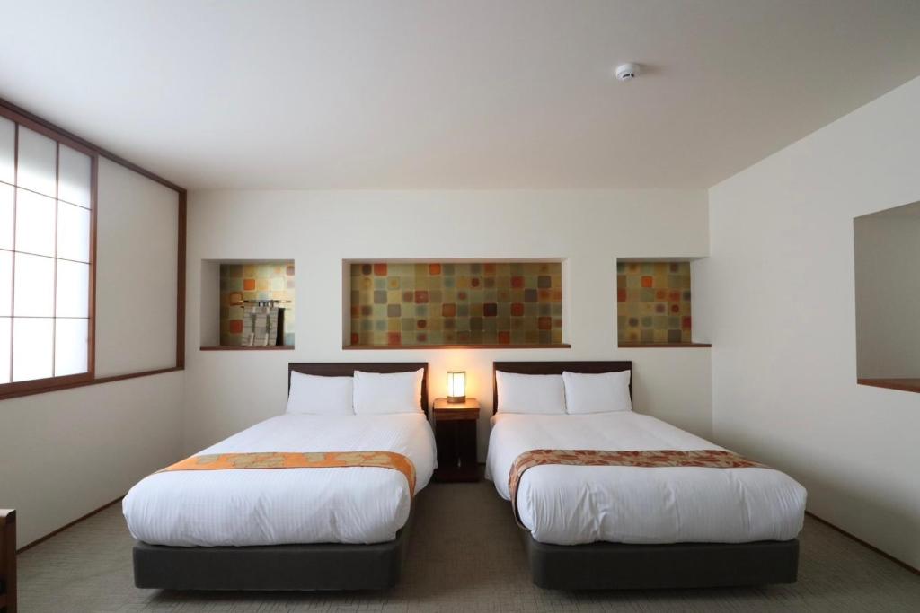 Postel nebo postele na pokoji v ubytování Hotel Rakurakuan