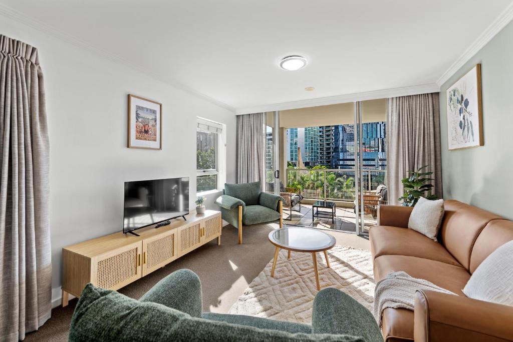 a living room with a couch and a tv at Prime City Residence with Pool, Gym and Parking in Brisbane