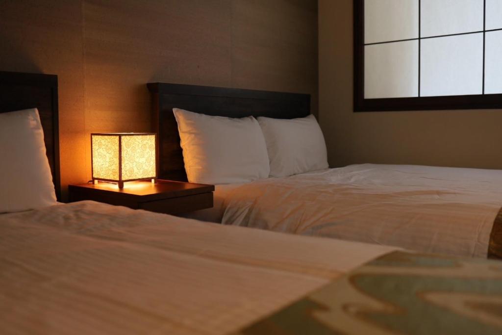 Postel nebo postele na pokoji v ubytování Hotel Rakurakuan