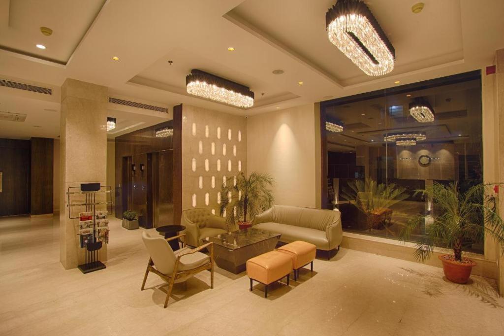 a lobby with a couch and chairs in a building at Presedent Airport Hotel Near Delhi International Airport in New Delhi