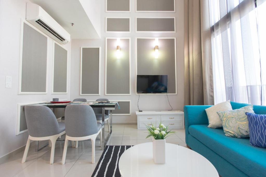 - un salon avec un canapé bleu et une table dans l'établissement Duplex @ I City by Bai Yi #2906, à Shah Alam
