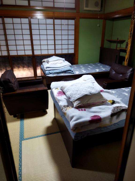 a room with two beds and a window at Private Room in Japanese Vintage House 民家の一室 2 Beds, Smoke Free, Free Parking Good to Travel for Tashiro Cats Island no1 in Ishinomaki