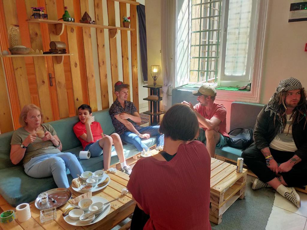 Rhala Hostel Egypt في القاهرة: مجموعة من الناس يجلسون في غرفة المعيشة