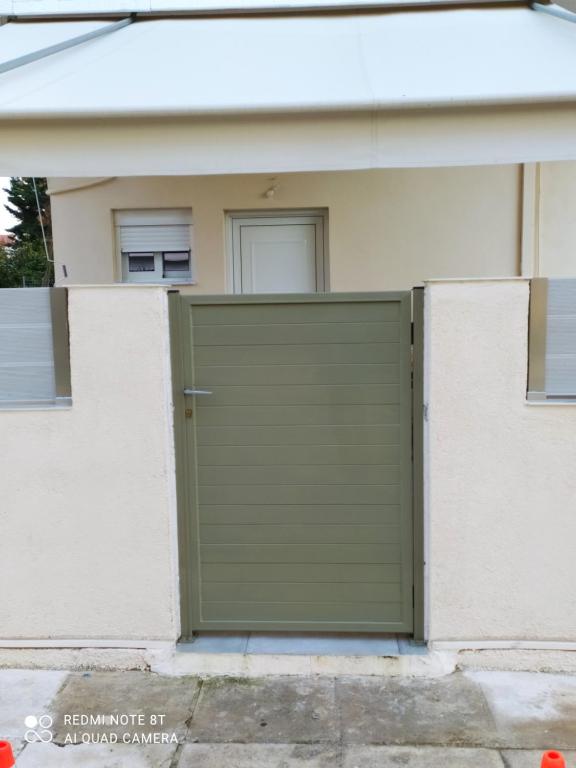 a green garage door in front of a house at D&K Studio - Nafplio in Nafplio
