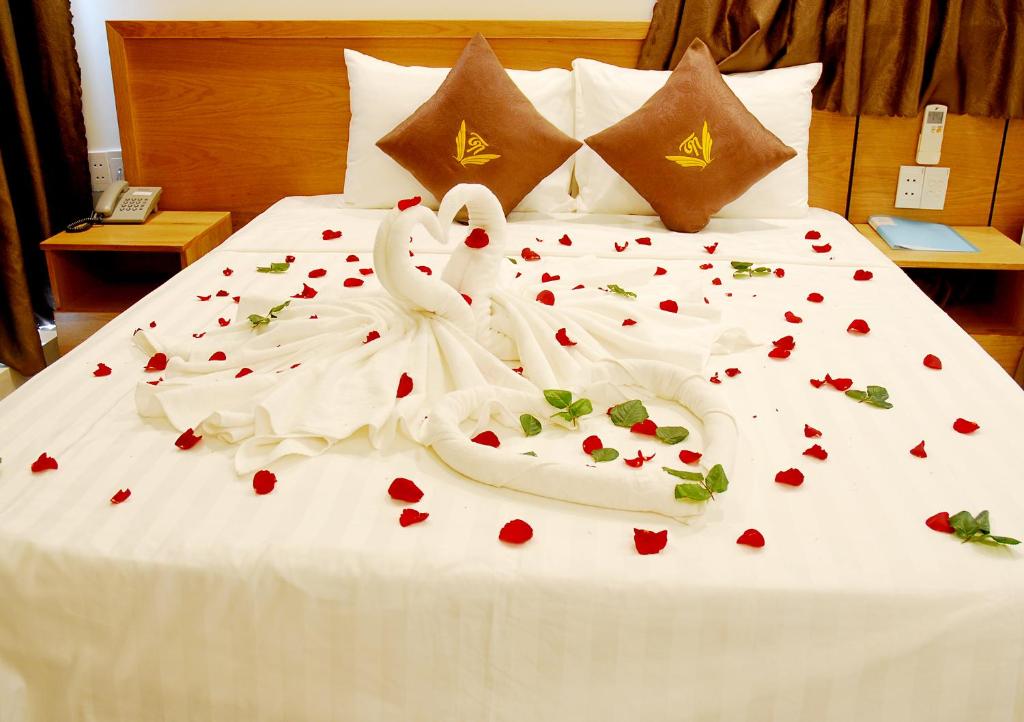 a bed with two swans made out of hearts at Trang Ngan Hotel by THG in Danang