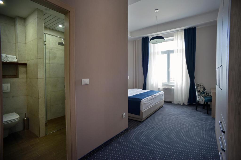 a bedroom with a bed and a bathroom with a shower at Five Points Square - City Center in Belgrade