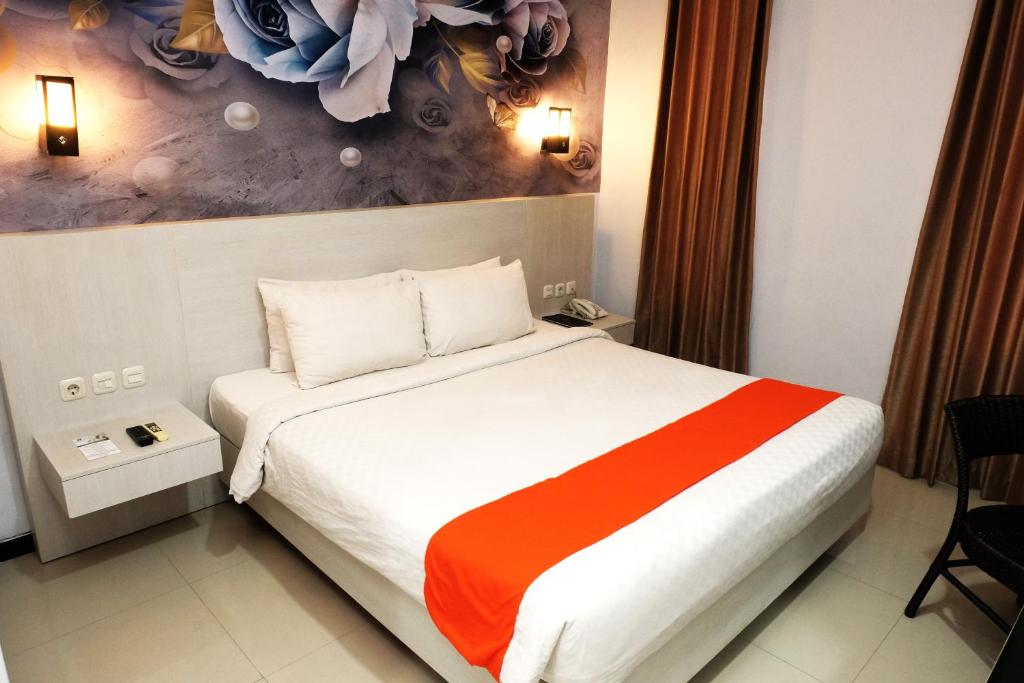 una habitación de hotel con una cama y un cuadro en la pared en Halogen Hotel Airport Surabaya, en Sidoarjo