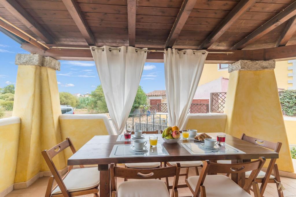een eetkamer met een tafel en stoelen op een balkon bij Dimora di Rosy Pittulongu in Olbia