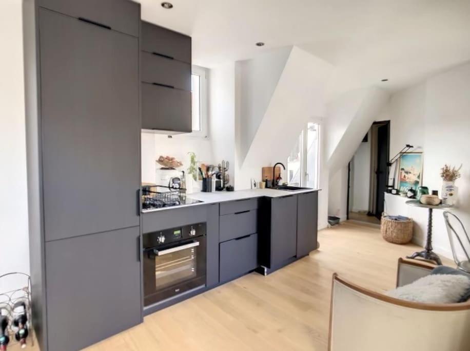 - une cuisine avec des appareils en noir et blanc dans l'établissement Appartement Design proche Tour Eiffel avec Balcon, à Paris