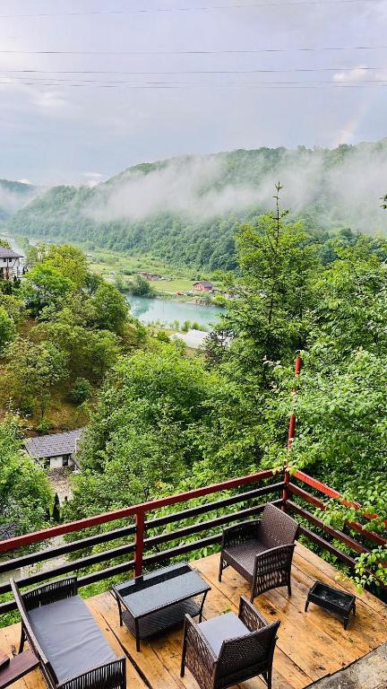 a deck with benches and a view of a mountain at Small Bosnian House in Bihać