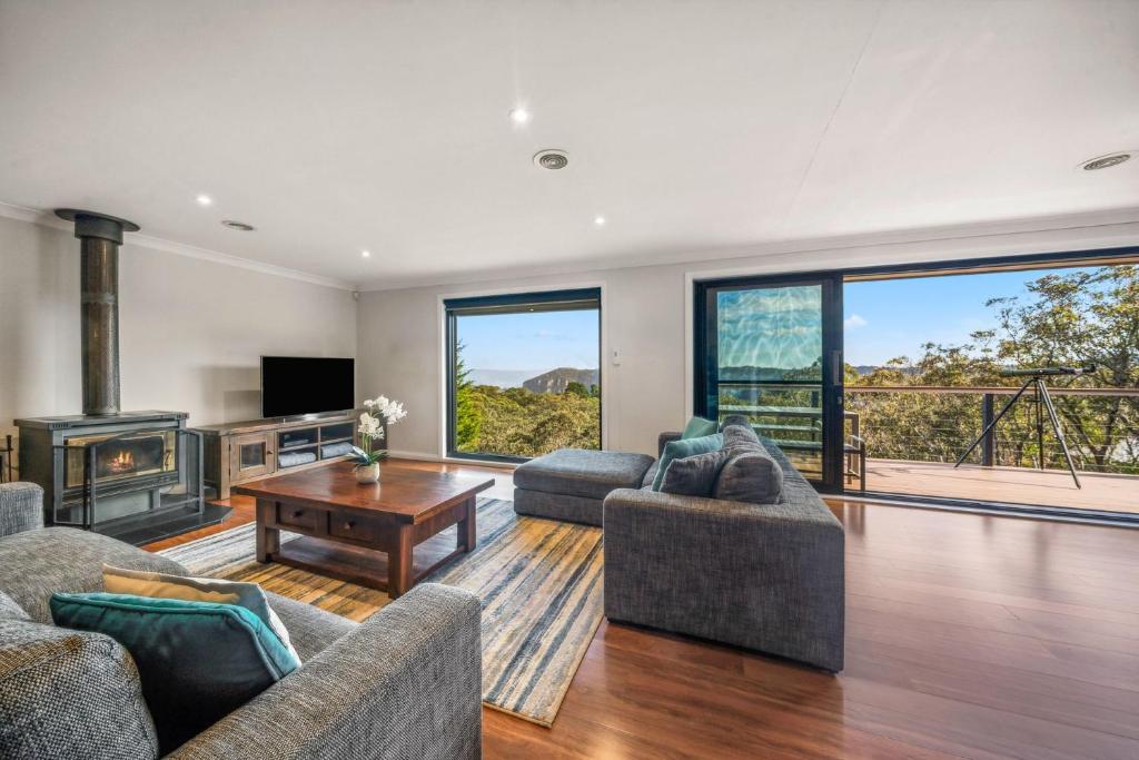 Una sala de estar con dos sofás y una chimenea. en Skycrest, en Katoomba