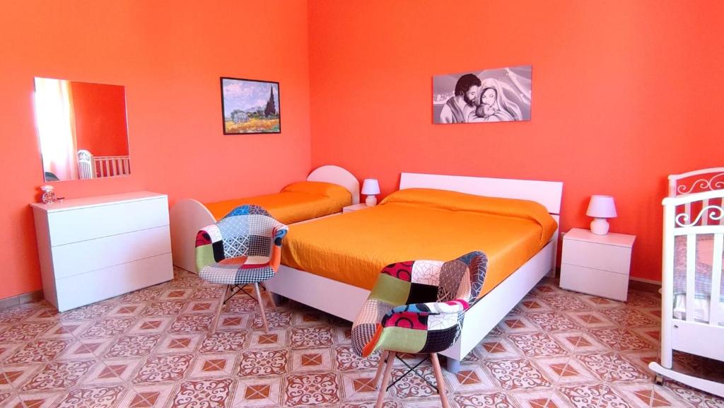 a bedroom with two beds and orange walls at Casa Vacanze Ramo in Mazara del Vallo