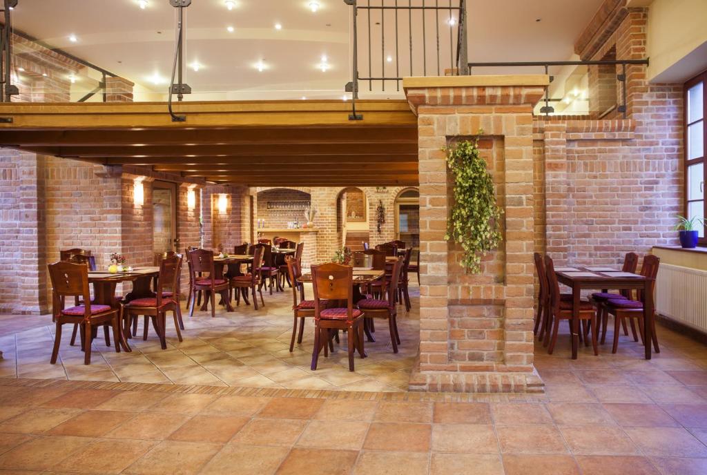 um restaurante com mesas e cadeiras e uma parede de tijolos em Hotel Aurelius Mikulov em Mikulov
