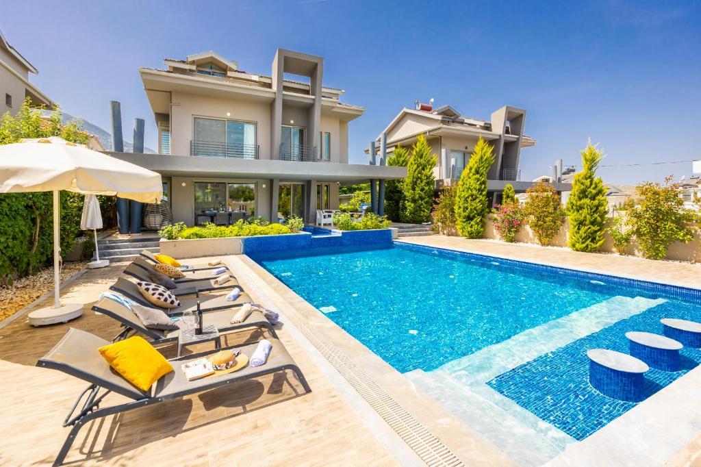 eine Villa mit einem Pool und einem Haus in der Unterkunft Villa Moderno B in Oludeniz
