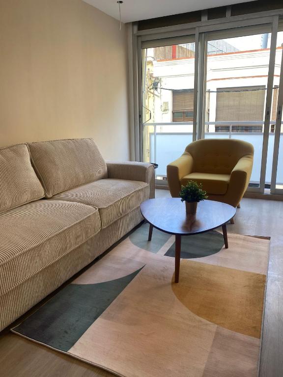 a living room with a couch and a table and a chair at Costa Sun Apartment in Calella