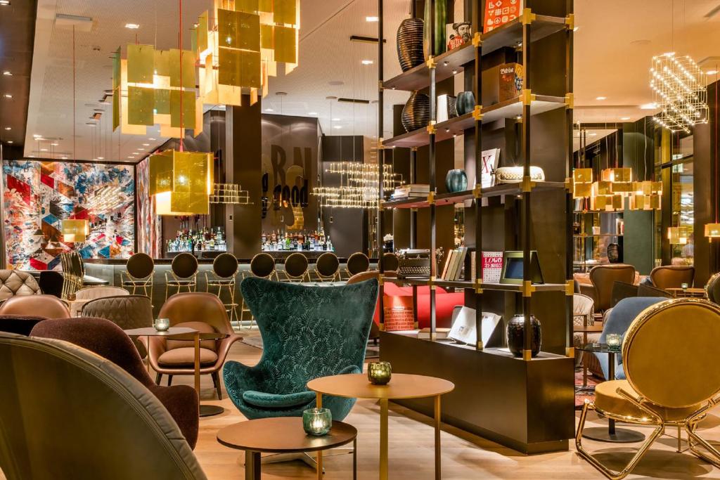 a restaurant with chairs and tables and a bar at Motel One Frankfurt-Römer in Frankfurt/Main