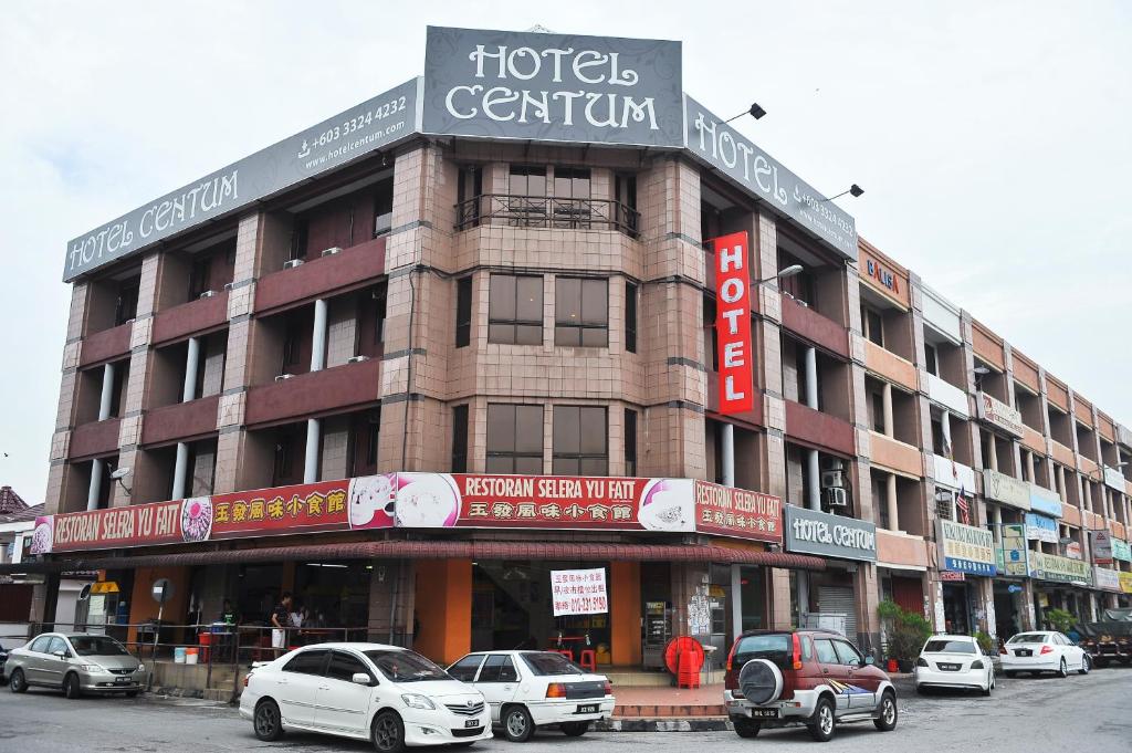 un gran edificio con coches estacionados frente a él en Hotel Centum en Klang