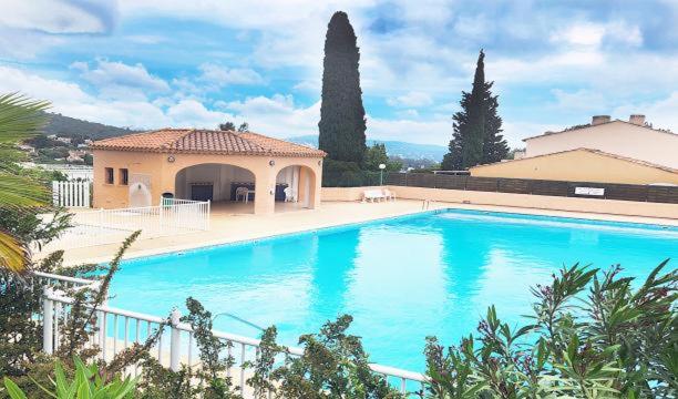 a large blue swimming pool in front of a house at Appartement avec piscine cozy spacieux, climatise, vue mer! Plages et centre 15 mns! in Cavalaire-sur-Mer