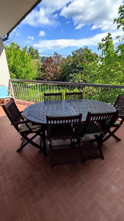 une table noire et des chaises sur une terrasse dans l'établissement Gîte 6 personnes Aubenas, à Saint-Didier-sous-Aubenas