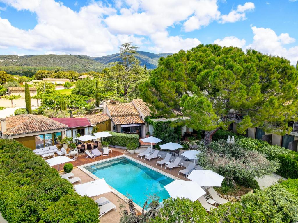 an aerial view of a house with a swimming pool and chairs at Hotel Bastide & SPA - Villa de Lourmarin in Lourmarin