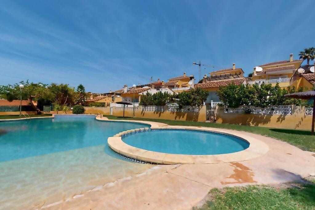 - une grande piscine dans une cour avec des maisons dans l'établissement Immaculate bungalow with amazing sea views, à Mutxamel