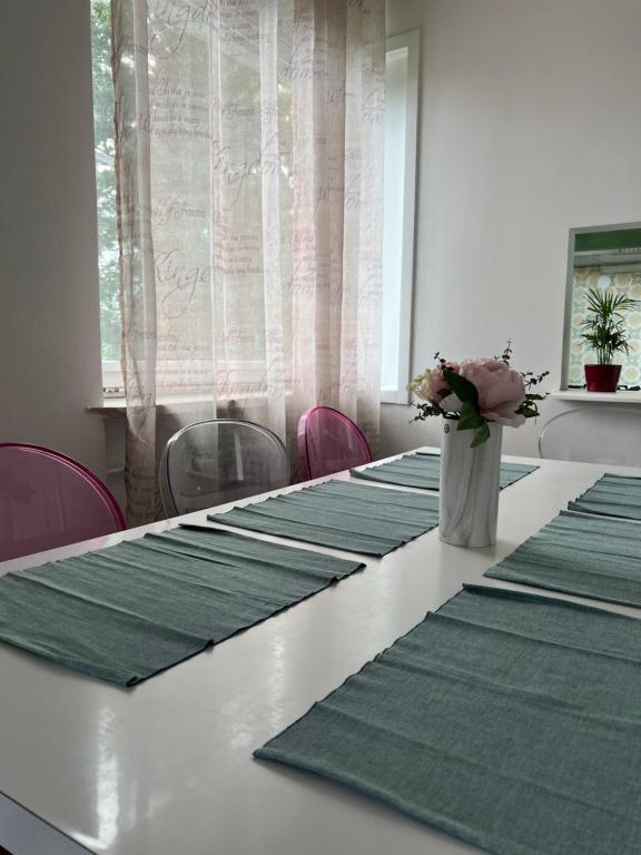 a long table with green mats and a vase of flowers on it at Apartment Ljubljana - Free parking in Ljubljana