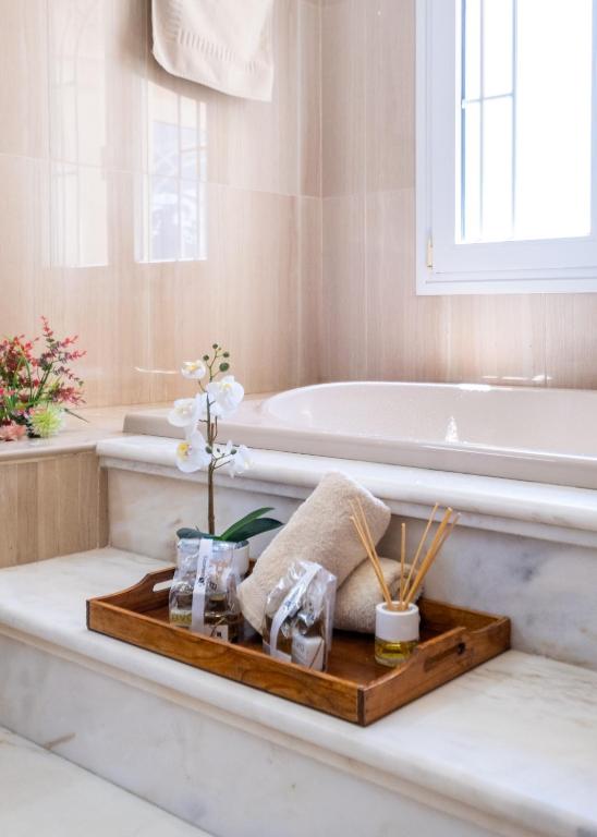 Hotel Villa María Teresa, a bathroom with a tray with flowers and a bath tub at Villa María Teresa in Málaga
