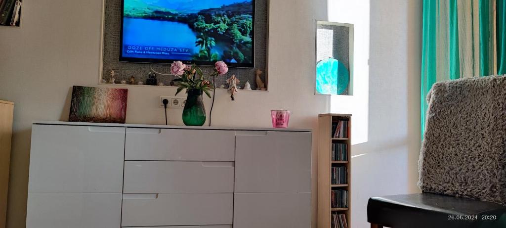 a living room with a tv on top of a dresser at Liepaja Beach in Liepāja