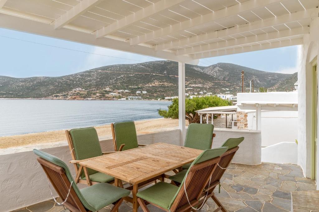 un tavolo e sedie su un patio con vista sull'acqua di Sifnos Waterfront House a Platis Yialos Sifnos