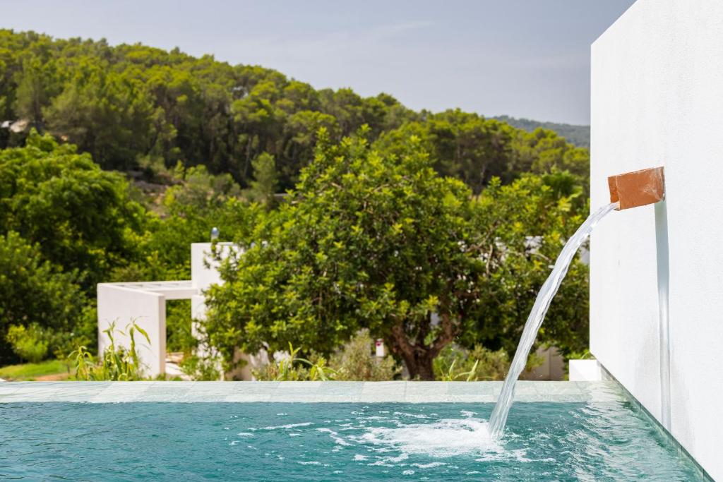 una piscina con una fuente de agua en una casa en Can Lluc Hotel Rural en Sant Rafel de sa Creu