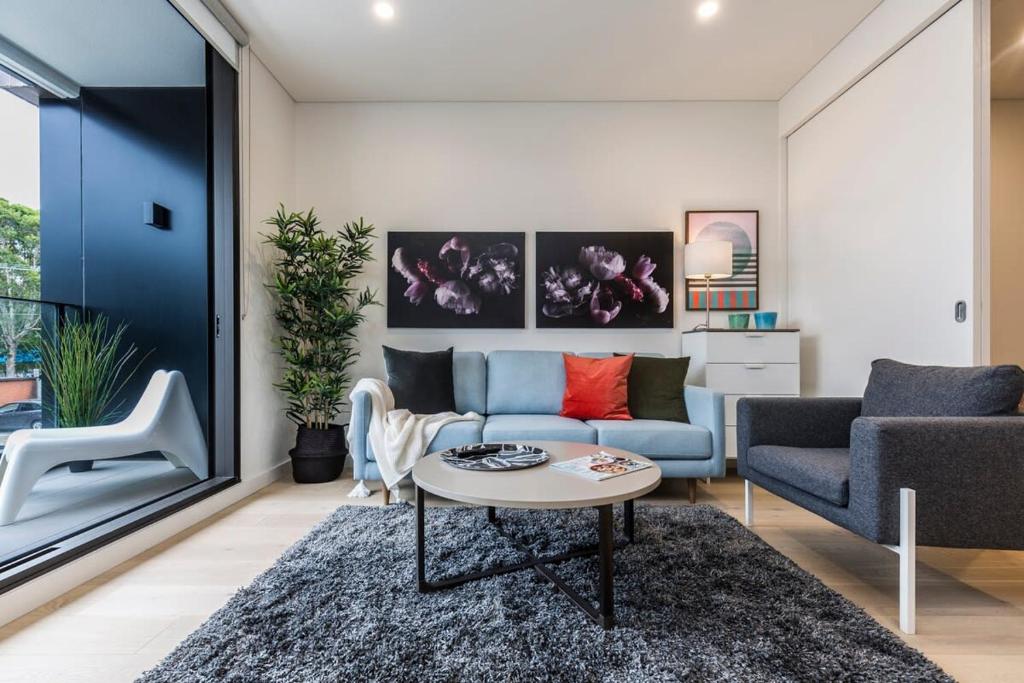 a living room with a couch and a table at Air Conditioned One Bedroom with Pool Close To CBD in Sydney