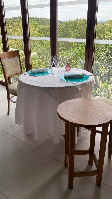 una mesa con mantel blanco y 2 sillas en Aux Vieux Arceaux, en Mercuer