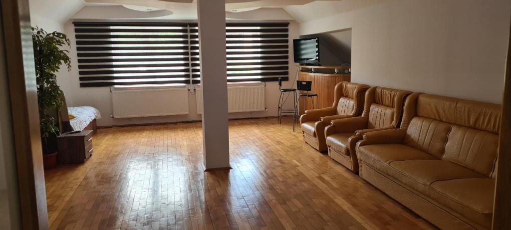 uma sala de estar com um sofá e uma janela em Ramhouse em Piteşti