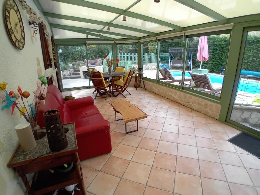 un salon avec un canapé rouge et une table dans l'établissement Le bonheur en Provence, à Trets